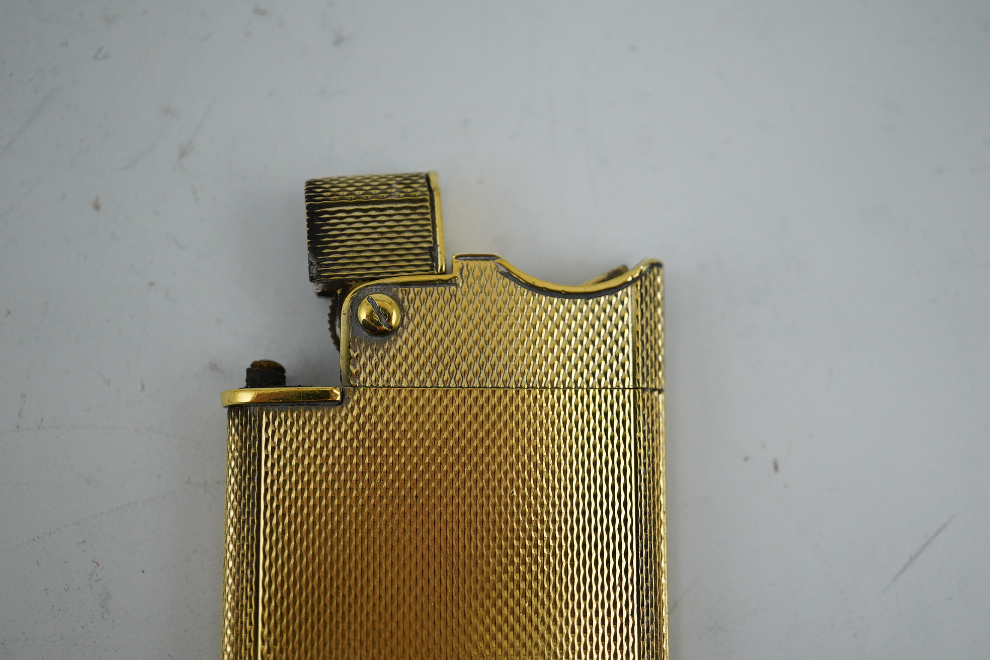 An Elizabeth II Asprey & Co engine turned silver gilt 'wafer' lighter